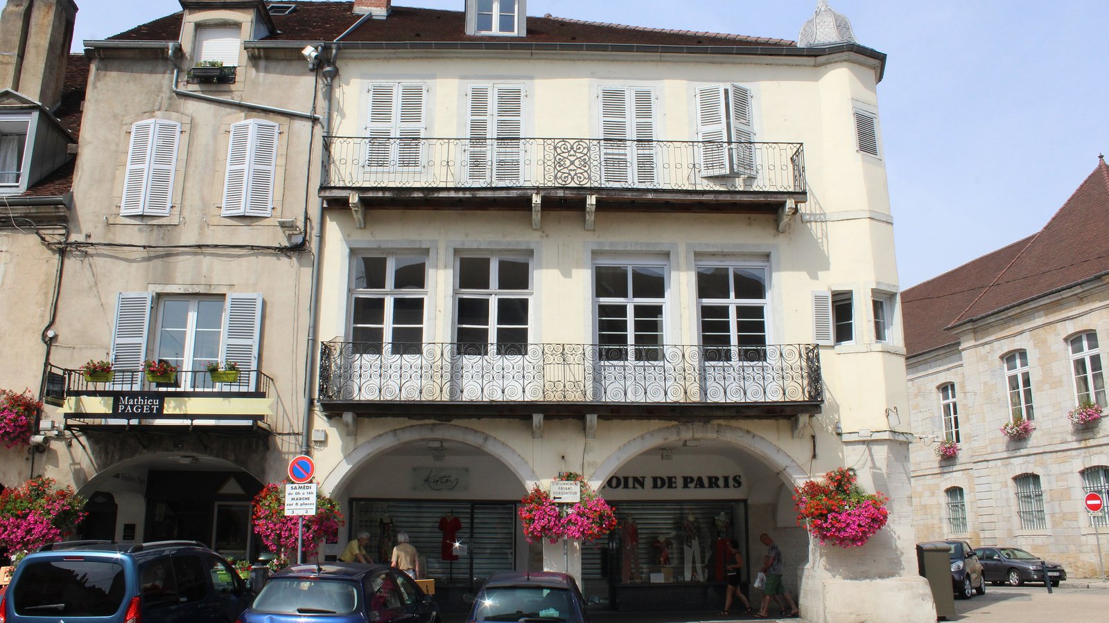 Immeuble ancien avec balcons en fer forgé, boutiques sous les arcades du rez-de-chaussée
