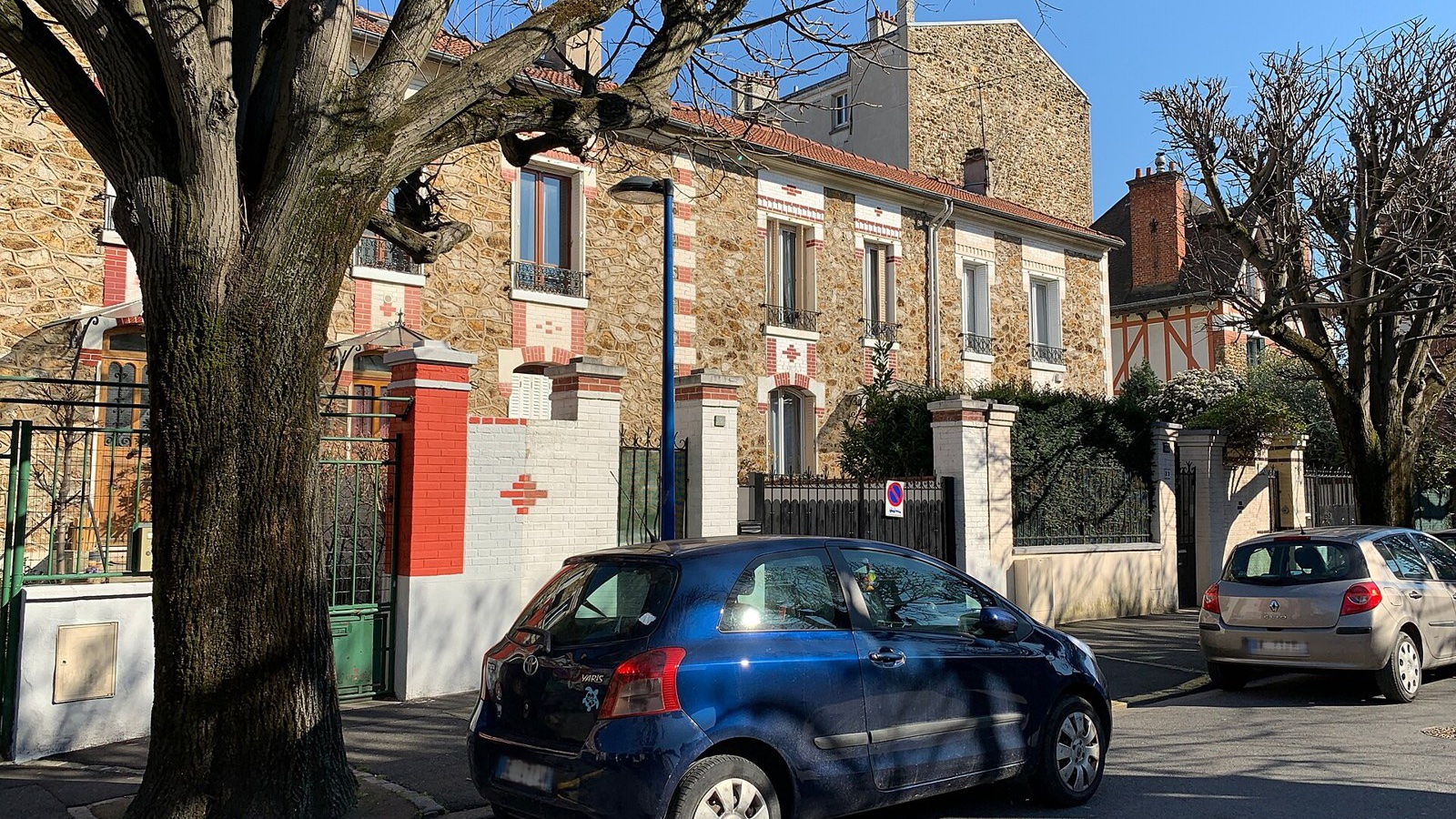 Maisons anciennes en meulière d'un lotissement, voitures garées devant