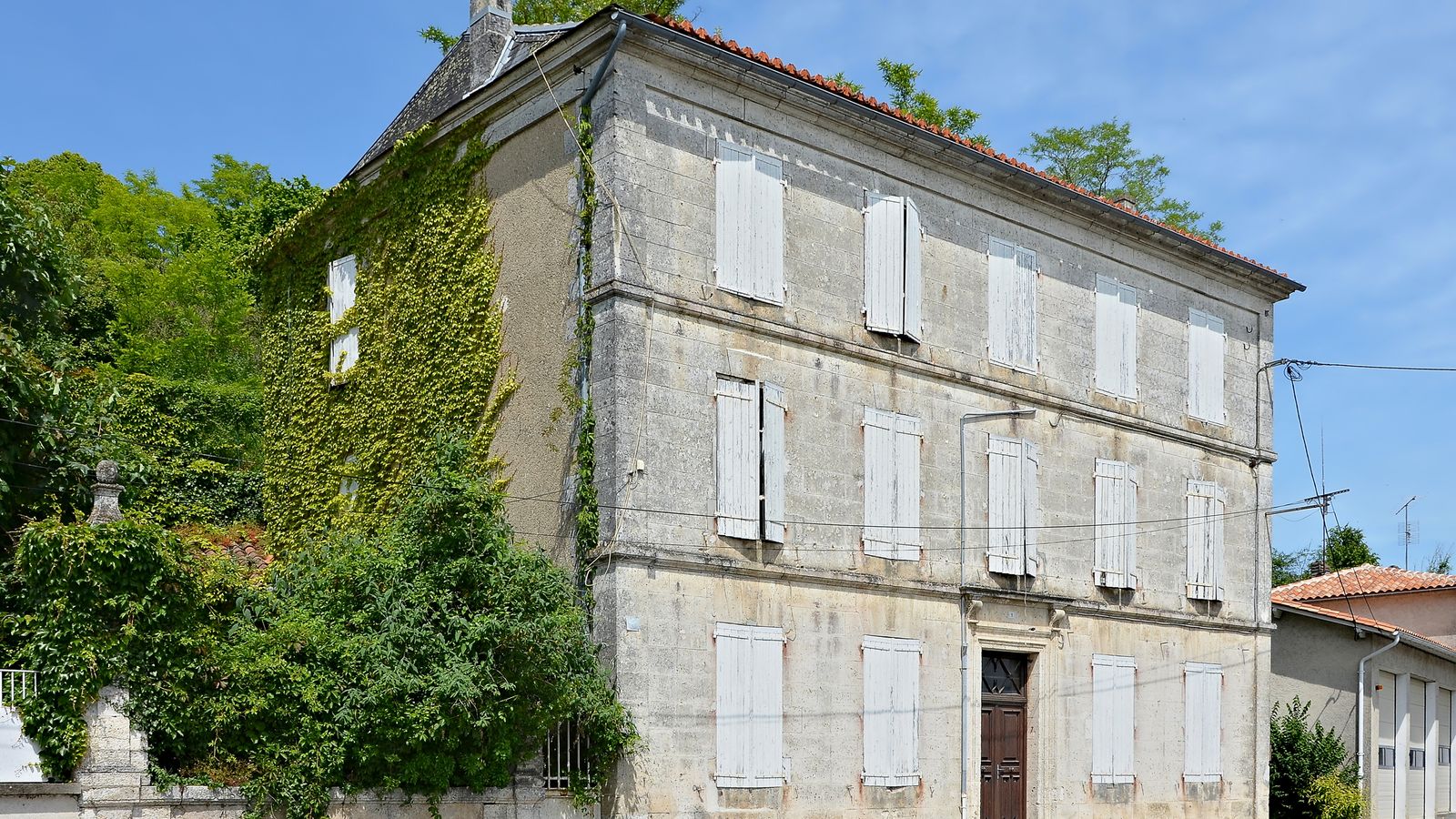Grande maison bourgeoise en pierre à trois niveaux, volets clos