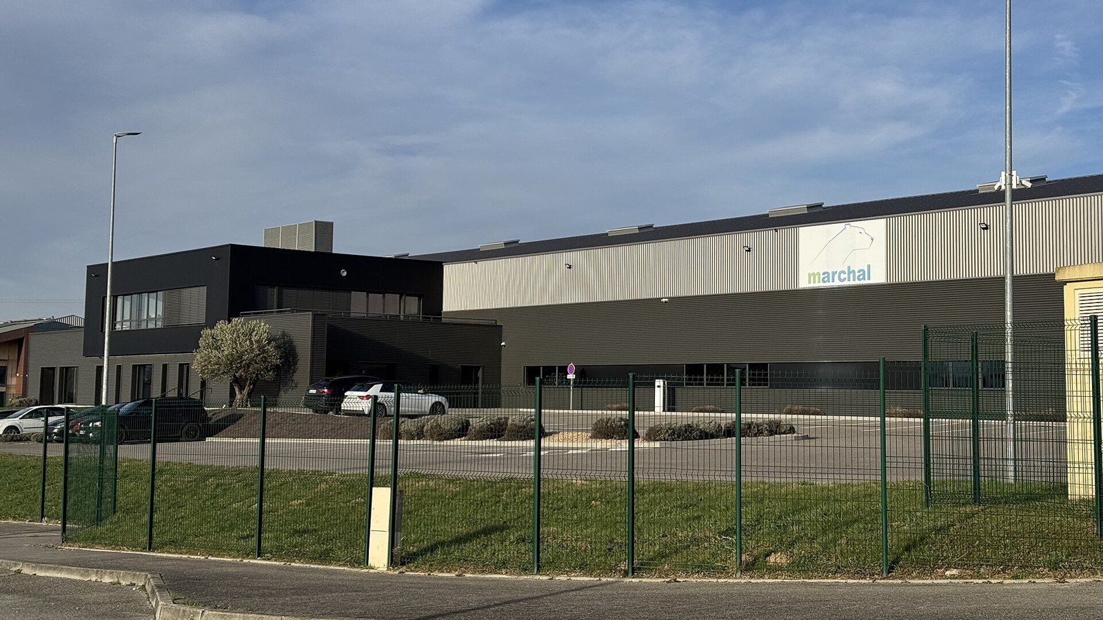 Bâtiment d'activité avec bureaux et ateliers derrière une clôture