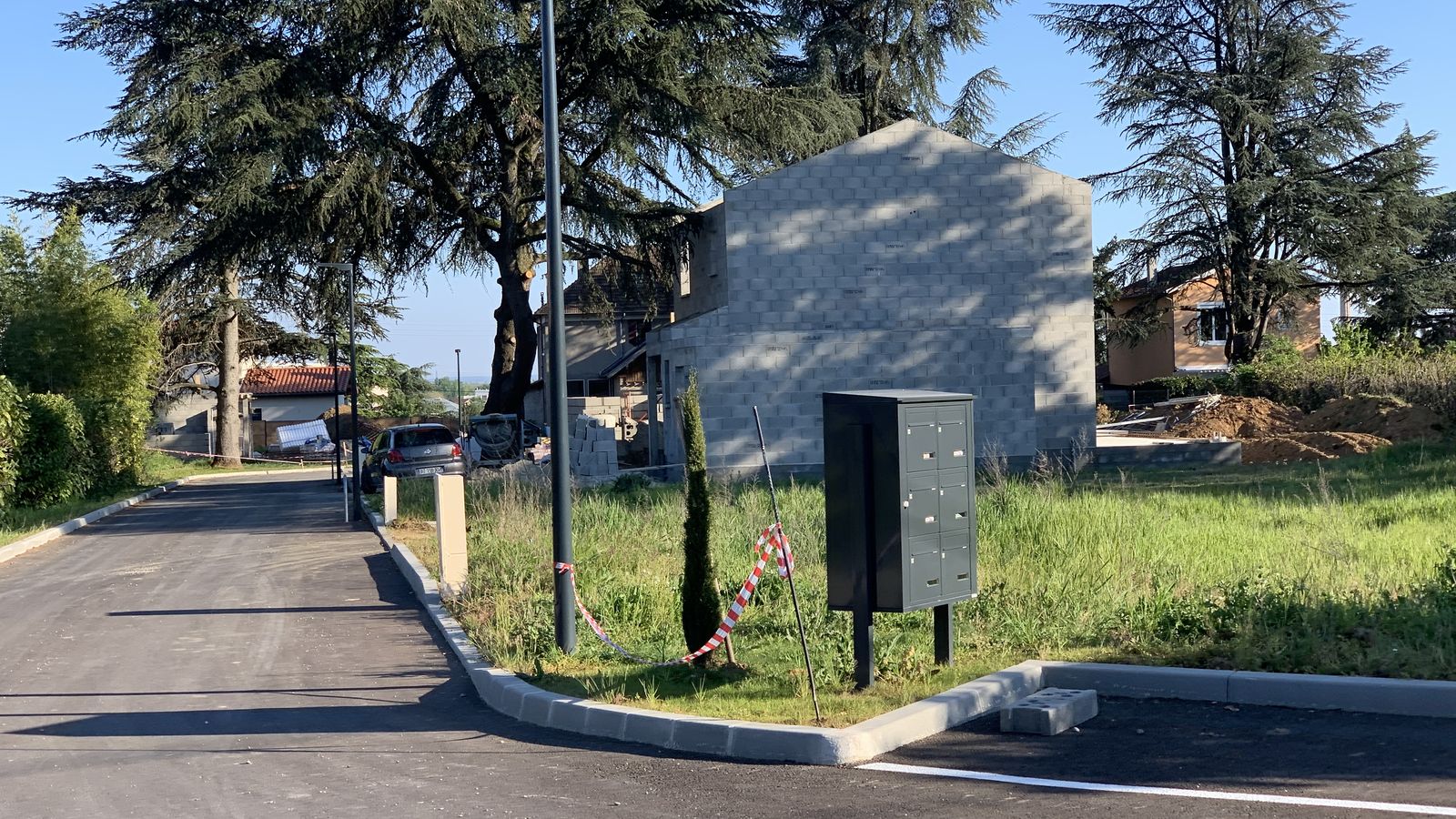 Rue neuve d'un lotissement avec une maison en construction