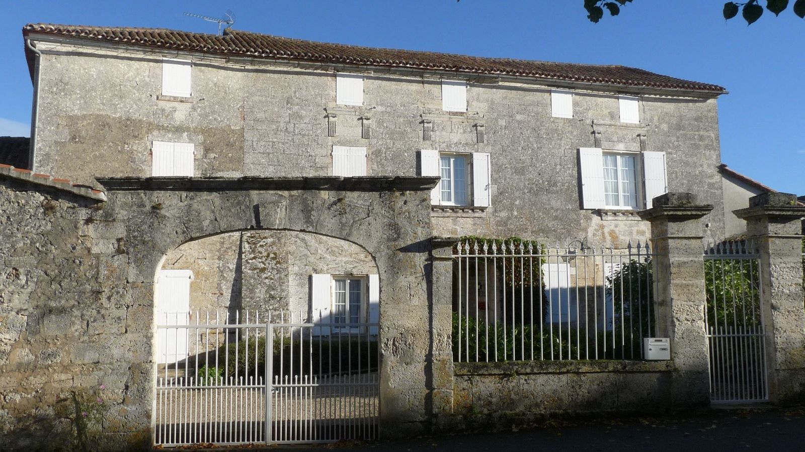 Maison charentaise en pierre avec son portail et son mur de clôture