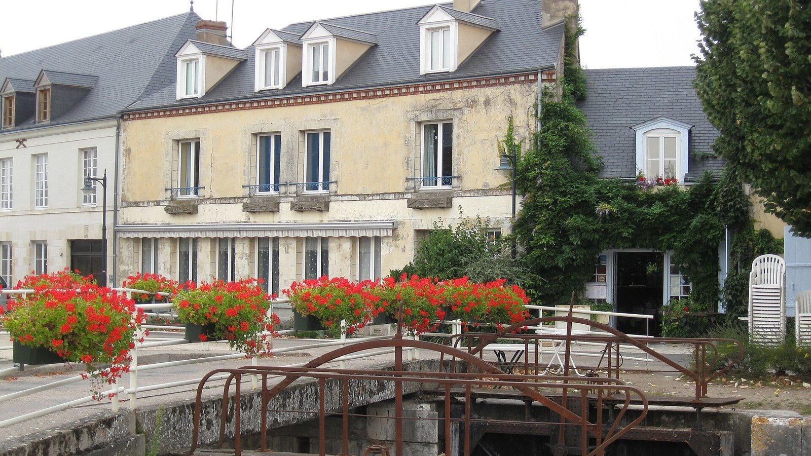 Maisons au bord d'un canal, géraniums rouges au premier plan