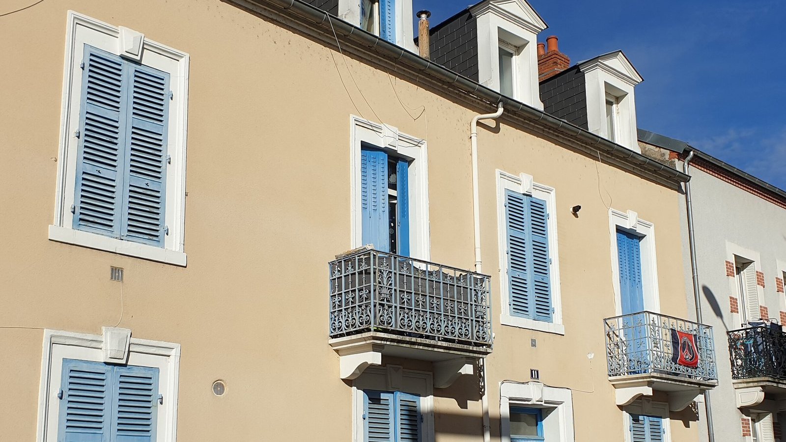 House front with closed blue shutters