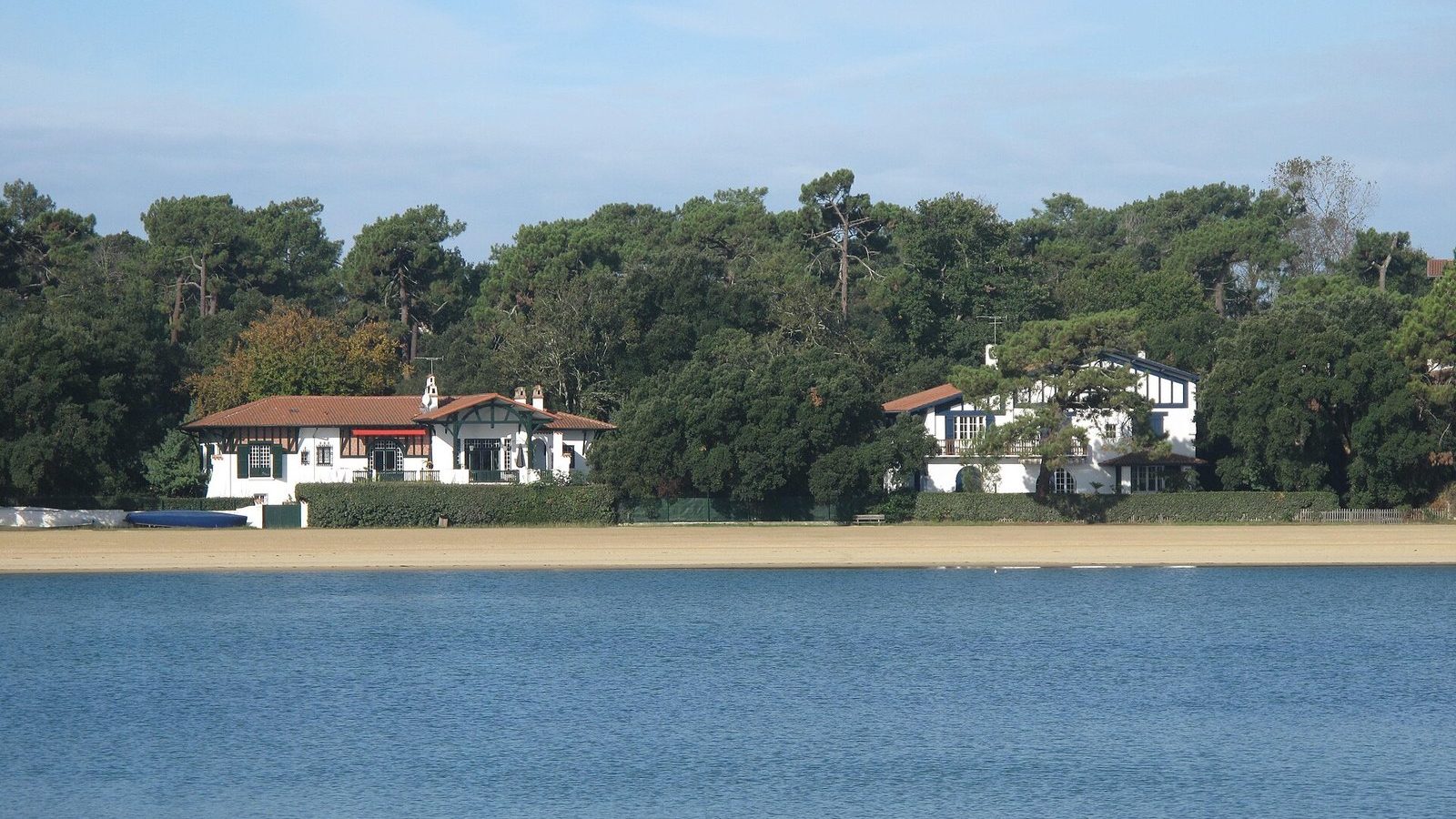 White half-timbered villas on the shore of Lake Hossegor, among pine trees