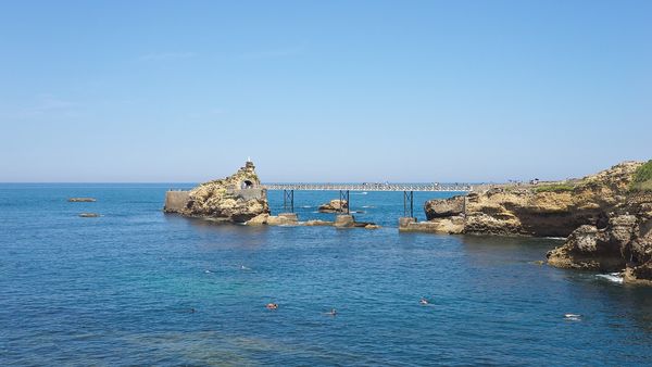 The Rocher de la Vierge and its footbridge in a blue sea