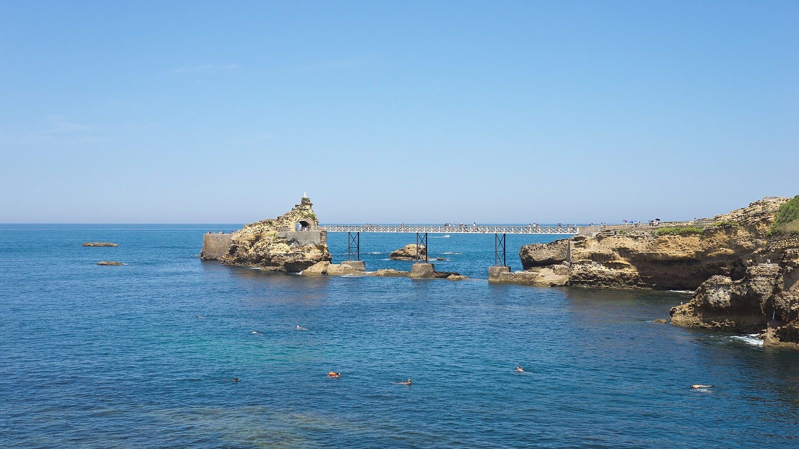 The Rocher de la Vierge and its footbridge in a blue sea
